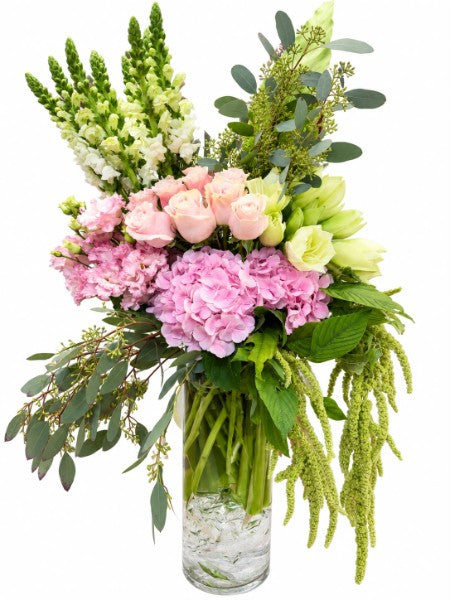Garden Romance Luxury Arrangement featuring pink hydrangeas, blush roses, white snapdragons, and green tulips in a glass cylinder vase