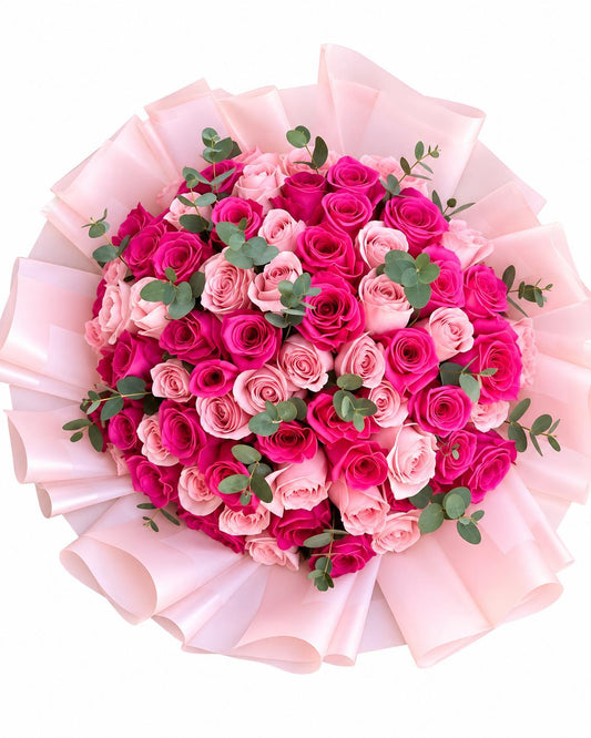 Pink and hot pink rose bouquet with eucalyptus wrapped in soft pink paper