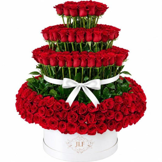 Tiered red rose arrangement in a white JLF signature hat box with white ribbon bow
